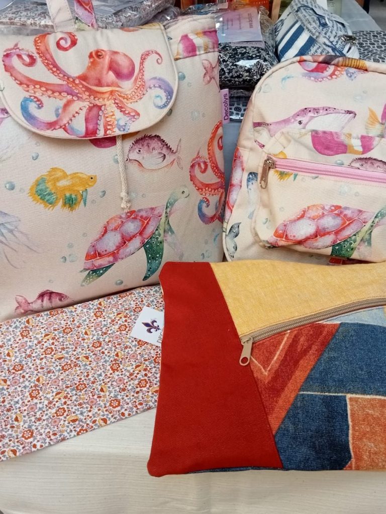Varias mochilas y fundas con estampados de pulpos y colores brillantes.